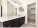 Bathroom with a double sink vanity, large mirror and walk-in closet at 515 E Sherri Dr, Gilbert, AZ 85296
