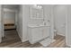 Bathroom featuring wood style flooring, white cabinets, matching hardware, and an inset sink at 5421 W Burton Dr, Phoenix, AZ 85043