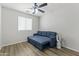 Bedroom with a blue sleeper sofa, a window, and a modern ceiling fan with lighting at 5421 W Burton Dr, Phoenix, AZ 85043