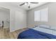 Bedroom features wood-look flooring, window, ceiling fan, bed and closet at 5421 W Burton Dr, Phoenix, AZ 85043