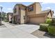 Tan two-story home showcasing a two-car garage and a well-maintained front yard with decorative rock at 5421 W Burton Dr, Phoenix, AZ 85043