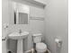 Clean half bathroom with a pedestal sink, toilet, and simple decor at 5421 W Burton Dr, Phoenix, AZ 85043