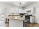 Kitchen featuring white cabinets, stainless steel appliances, and a granite-topped island at 5421 W Burton Dr, Phoenix, AZ 85043