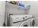 Modern laundry room featuring a Samsung washer and dryer, with storage shelf above at 5421 W Burton Dr, Phoenix, AZ 85043