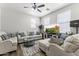 Bright living room with neutral sofas, a ceiling fan, a modern rug, and a large flat-screen TV at 5421 W Burton Dr, Phoenix, AZ 85043