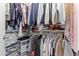 Walk-in closet with built-in shelving with clothing hanging on rods in the top and middle sections at 5421 W Burton Dr, Phoenix, AZ 85043