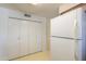 Kitchen featuring white appliances and wood cabinets with double door pantry at 5800 S College Ave, Tempe, AZ 85283