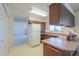 Compact kitchen featuring wood cabinets and all white appliances at 5800 S College Ave, Tempe, AZ 85283