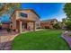 An expansive backyard with green grass, a covered patio, and a walkway at 7246 W Monte Cristo Ave, Peoria, AZ 85382