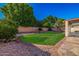Well-maintained backyard with lush lawn, stone patio, and mature trees at 7246 W Monte Cristo Ave, Peoria, AZ 85382