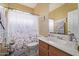 A clean and classic bathroom featuring a wood vanity and a shower with patterned curtain at 7246 W Monte Cristo Ave, Peoria, AZ 85382