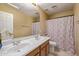 Bright bathroom features a double sink vanity, large mirror, and a patterned shower curtain at 7246 W Monte Cristo Ave, Peoria, AZ 85382