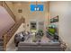 Bright, open living room featuring a high ceiling, large window, comfortable seating, and stairs to the second floor at 7246 W Monte Cristo Ave, Peoria, AZ 85382