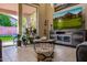 Cozy living room featuring sliding glass doors, plants, and an entertainment center with a large-screen television at 7246 W Monte Cristo Ave, Peoria, AZ 85382