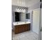 This bathroom features a double sink vanity with framed mirrors and tile floors at 9911 W Riverside Ave, Tolleson, AZ 85353