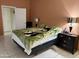 Comfortable bedroom featuring tile floors, lamps, and a large bed at 9911 W Riverside Ave, Tolleson, AZ 85353