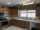 Functional kitchen with tile floors, stainless steel appliances, wood cabinets, and a large window for plenty of light at 9911 W Riverside Ave, Tolleson, AZ 85353