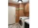 Laundry room with a front-loading washer and dryer, cabinets, and a palm tree-themed wallpaper border at 9911 W Riverside Ave, Tolleson, AZ 85353
