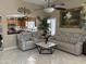 Inviting living room with neutral colors, tile floors, high ceilings, lots of light, and a peek at the kitchen at 9911 W Riverside Ave, Tolleson, AZ 85353