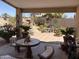 Covered patio with mosaic tile table and bench seating overlooking landscaped backyard at 9911 W Riverside Ave, Tolleson, AZ 85353