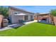 Expansive backyard featuring artificial grass, outdoor dining area, and gazebo with seating at 9918 E Escondido Ave, Mesa, AZ 85208