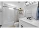 Bright bathroom with a shower/bathtub combo, white vanity and black fixtures at 9918 E Escondido Ave, Mesa, AZ 85208
