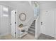 Bright foyer showcasing a staircase, round mirror and hardwood floors at 9918 E Escondido Ave, Mesa, AZ 85208