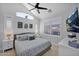 Bright main bedroom with a ceiling fan, white walls, plantation shutters and a TV with scenic views at 9918 E Escondido Ave, Mesa, AZ 85208