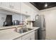 Galley kitchen featuring modern appliances, white cabinetry, and a view into the living area at 10410 N Cave Creek Rd # 2229, Phoenix, AZ 85020