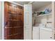 Conveniently located laundry room with washer, dryer, storage shelves, and easy access to outside at 10410 N Cave Creek Rd # 2229, Phoenix, AZ 85020