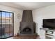 Cozy living room with a rustic fireplace, entertainment center, and a sliding glass door to the patio at 10410 N Cave Creek Rd # 2229, Phoenix, AZ 85020