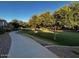 Community walking path winding through mature trees and grassy areas, perfect for exercise and enjoying nature at 1350 S Greenfield Rd # 1219, Mesa, AZ 85206