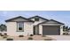 Charming single-story home with neutral stucco, complemented by grey accents and a two-car garage at 15731 W Brown St, Waddell, AZ 85355