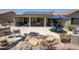 This back patio includes an outdoor kitchen, dining and seating areas, and a serene water feature at 15953 W Catalina Dr, Goodyear, AZ 85395