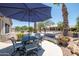 Backyard patio showcases a patio umbrella, comfortable seating, and well-manicured landscaping with desert plants at 15953 W Catalina Dr, Goodyear, AZ 85395
