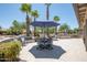 Backyard oasis boasts a built-in grill, comfortable seating, and mature trees providing ample shade at 15953 W Catalina Dr, Goodyear, AZ 85395