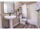 Bright bathroom featuring a pedestal sink, modern fixtures, and a shower-tub combo with a stylish shower curtain at 15953 W Catalina Dr, Goodyear, AZ 85395