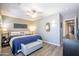 Bright bedroom featuring a ceiling fan, modern décor, bench, and neutral walls at 15953 W Catalina Dr, Goodyear, AZ 85395
