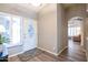 Bright foyer with views to the living room, decorative mirror and a modern front door at 15953 W Catalina Dr, Goodyear, AZ 85395