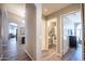 Hallway showcasing hardwood floors, modern lighting, and open doorway leading to a full bathroom at 15953 W Catalina Dr, Goodyear, AZ 85395