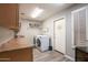 Laundry room with wood floors, newer washer and dryer, counter space, and built-in storage at 15953 W Catalina Dr, Goodyear, AZ 85395