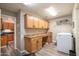Well-lit laundry room features ample counter space, storage cabinets, and modern washer and dryer at 15953 W Catalina Dr, Goodyear, AZ 85395