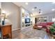 Bright living room features custom shelves, a red sectional sofa, and new hardwood flooring at 15953 W Catalina Dr, Goodyear, AZ 85395