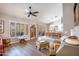 Spacious living room with hardwood floors, lots of natural light, a ceiling fan, and easy access to the dining room at 15953 W Catalina Dr, Goodyear, AZ 85395