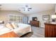 Inviting main bedroom featuring a ceiling fan, wood floors, storage cabinet, and a window with white shutters at 15953 W Catalina Dr, Goodyear, AZ 85395