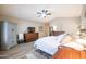 Bright main bedroom featuring a ceiling fan, wood floors, a storage cabinet, and wood furniture at 15953 W Catalina Dr, Goodyear, AZ 85395