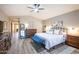 Spacious main bedroom with hardwood floors, ceiling fan, dresser, mirror, and neutral color palette at 15953 W Catalina Dr, Goodyear, AZ 85395