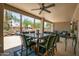 Covered patio features a ceiling fan, dining table, and scenic backyard views, perfect for outdoor dining at 15953 W Catalina Dr, Goodyear, AZ 85395