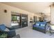 Covered patio with comfortable seating, ceiling fans, and view of the landscaped backyard at 15953 W Catalina Dr, Goodyear, AZ 85395