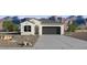 Charming single-story home featuring desert landscaping and a two-car garage, set against a backdrop of striking mountains at 18354 W Hackamore Dr, Wittmann, AZ 85361
